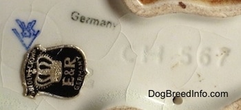 Close up - The underside of a Boxer puppy figurine. The figurine has the Goebel W. Germny logo on it, under that is a black and silver Golden Crown E & R Germany sticker and to the right of those is the number CH567.