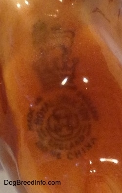 Close up - A Royal Doultan logo that is on the underside of a Chow Chow figurine.