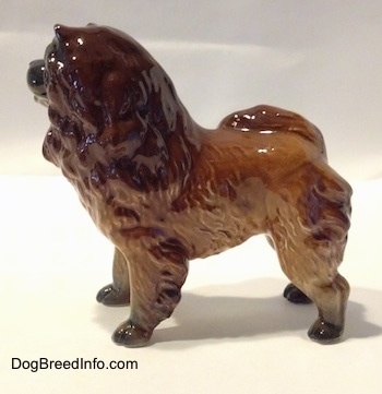 The left side of a brown with black Chow Chow figurine. The figurine has fine hair details. The figurine has black paws.