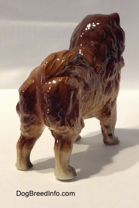 The back right side of a brown with black Chow Chow figurine. 