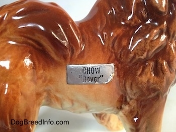 Close up - A sticker on a Chow Chow figurine. The sticker reads - Chow 'lover'.