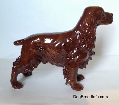 The right side of a brown with black Cocker Spaniel porcelain figurine. It has a short tail.