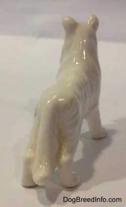 The back of a white bone china figurine that is of a Rough Collie dog. The tail of the figurine is long.