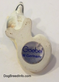 The underside of a Collie dog figurine. There is a sticker that reads - Goebel W.Germany - on it.