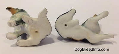 The underside of two bone china Rough Collie figurines. There are small holes at the bottom of the figurine.
