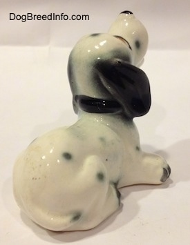 The back right side of a Dalmatian puppy figurine. It is hard to differentiate the tail of the figurine from the body.