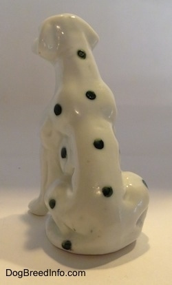 The back side of a Dalmatian puppy in a sitting pose figurine. The figurine has four dots in a line down its back.