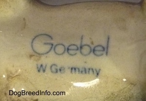 Close up - The underside of a Doberman Pinscher puppy figurine that has the text logo of Goebel W.Germany on it.