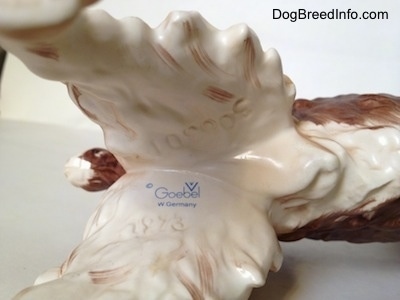 The underside of a English Springer Spaniel figurine. On the underside there is a stamped logo of Goebel W.Germany and above it is the engraved number - 306301.