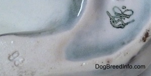 Close up - The underside of a French Bulldog figurine. There is the crown mark logo of Goebel W.Germany.