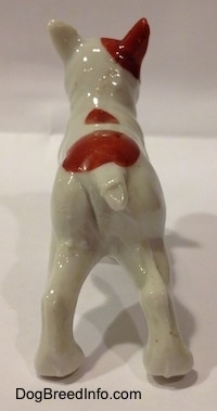 The back of a bone china figurine of a French Bulldog figurine that has a short white tail.