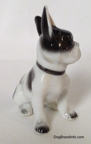 A figurine of a white and black French Bulldog in a sitting pose. The figurine is glossy.