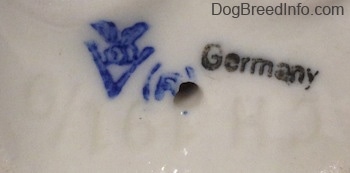 Close up - The underside of a French Bulldog figurine. There is a stamped logo of Goebel W.Germany and next to that is a stamp that reads - Germany. There is a combination of letters/numbers - CH 191/0 - engraved on the figurine.