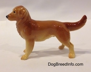 The left side of a brown with tan Golden Retriever. It is hard to differentiate the ears of the figurine from its body.