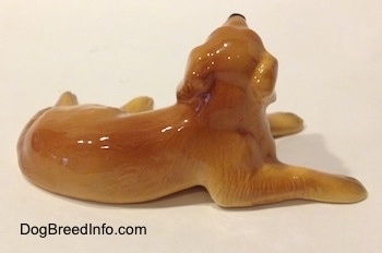 The right side of a Golden Retriever figurine in a laying down pose. The back of the figurine is glossy.