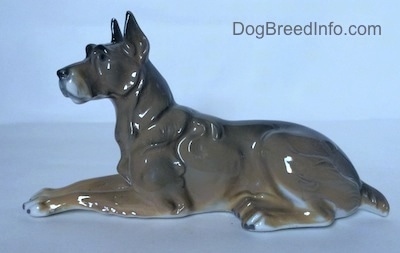 The left side of a figurine of a Great Dane. The figurine has white paws with black tipped nails.