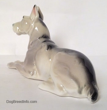The back left side of a Great Dane figurine laying down.