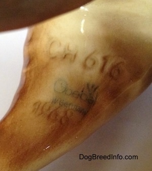 Close up - On the back left leg of a brown Labrador Retriever figurine. The number/letter combination of CH 616 and under that is the stamp of the Goebel W Germnay logo.