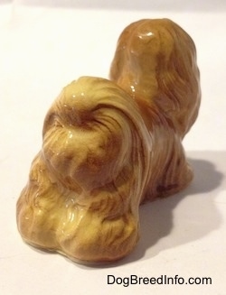 The back right side of a brown Lhasa Apso figurine with fine hair details.