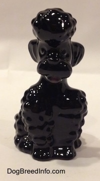 A black Poodle sitting figurine. The figurine has lots of hair lumps.