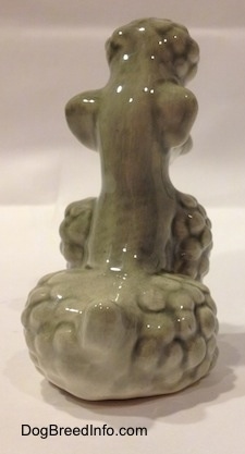 The back of a gray Poodle figurine that is in a sitting position. The figurine has a short tail.