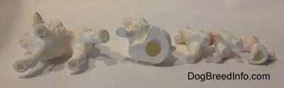 The underside of four bone china Poodle figurines.