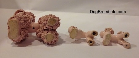 The underside of three porcelain pink Spaghetti Poodle figurines.