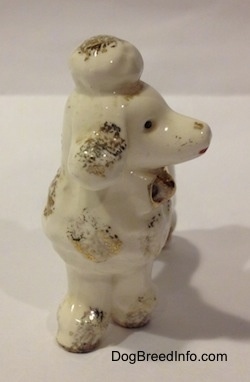 A porcelain figurine of a Poodle puppy. The figurine has its mouth painted open.