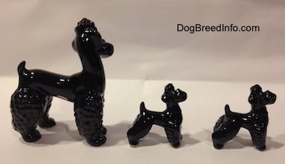 The right side of three figurines that are black Poodles. The figurines have there mouths open.