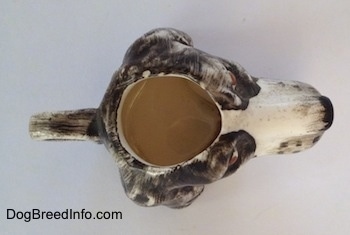 Top down view of a brown and white Russian Spaniel dog stein cup. The inside of the cup is empty.