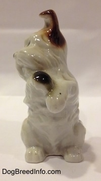 A parti-colored Miniature Schnauzer figurine in a begging a pose. The figurine has fine and complete hair details.