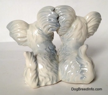 The back of a silver platinum figurine of a Siamese twin Skye Terrier sitting figurine.