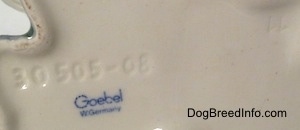 Close up - The underside of a Siamese Twin Skye Terrier figurine and there is the blue stamp of Goebel W.Gemrnay and above it is an engraving that reads '30 505-08'.